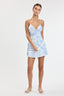 Woman wearing a light blue floral dress on a white background