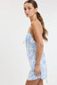 Woman wearing a blue and white patterned dress on a white background