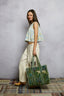 Woman holding a patterned bag against a plain background