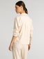 Woman wearing a beige suit on a plain background