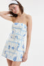 Woman wearing a strapless dress with blue pattern on a white background