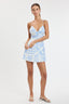 Woman wearing a light blue floral dress on a white background
