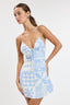 Woman wearing a blue and white patterned dress on a plain background