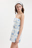 Woman wearing a strapless dress with blue floral pattern on a white background