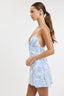 Woman wearing a light blue and white patterned dress on a white background