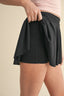 Person wearing a black skirt with a plain background