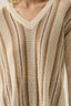 Close-up of a person wearing a beige and brown striped sweater.