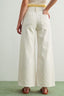 Person wearing white wide-leg pants on a plain background