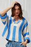 Woman wearing a blue and beige striped sweater against a white background
