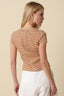 Woman wearing a brown and white striped top with a beige background