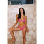 Woman in a pink bikini standing against a tiled wall.