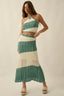 Woman wearing a green and white striped crochet dress on a beige background