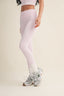 Person wearing light pink leggings and white sneakers on a beige background