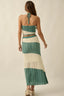 Woman wearing a green and white striped dress on a beige background