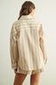 Person wearing a beige and white striped shirt with a plain background