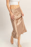 Beige satin skirt worn by a person on a plain background