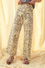 Person wearing floral-patterned pants on a beige background
