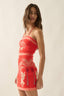 Woman wearing a red dress with white patterns on a beige background