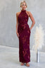 Woman wearing a burgundy lace halter neck gown against a gray background