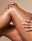 Close-up of a person's legs with hands on a beige background