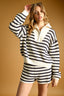 Person wearing a black and white striped outfit against a beige background