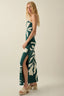 Woman wearing a green dress with white floral patterns on a beige background