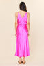 Woman wearing a pink satin dress on a beige background