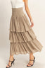 Beige tiered skirt worn by a person on a plain background
