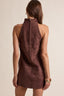 Brown suede dress worn by a person on a beige background