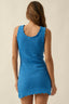 Blue crochet dress worn by a person on a beige background