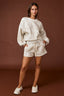 Woman wearing a white outfit on a brown background