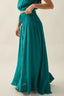 Teal dress with a long skirt and top on a neutral background