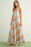 Woman wearing a long striped dress on a plain background