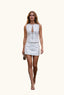 A woman wearing a white sleeveless mini dress with a front keyhole cutout and silver zipper detailing. 
