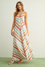 Woman wearing a long, striped dress with a neutral background