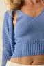 Blue knitted top worn by a person on a neutral background