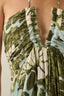 Close-up of a patterned dress with green, white, and beige colors.