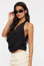 Woman wearing a black halter top and white skirt on a plain background