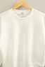 White sweatshirt on a wooden hanger against a light gray background