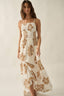 Woman wearing a white dress with brown floral patterns on a plain background