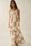 Woman wearing a white dress with brown floral patterns on a plain background