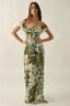 Woman wearing a floral off-shoulder dress on a plain background