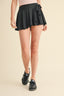 Person wearing a black skirt with a beige background