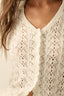 Woman wearing a white pointelle crochet outfit against a plain background