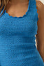 Blue crochet top worn by a person, with a neutral background
