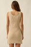 Beige crochet dress worn by a model on a plain background