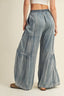 Denim wide-leg pants worn by a person on a beige background