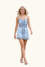Woman in a light blue dress walking outdoors on a sunny day.