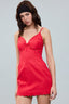 Woman wearing a red dress with thin straps on a gray background