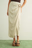 Person wearing a beige wrap skirt with a belt against a white background